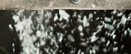 Polymetylmetakrylat (PMMA) plastgranulat faller genom en industriell återvinningsprocess