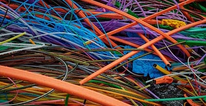 Färgade kabelmantlar i plast i en oordnad hög, för återvinning av plastmaterial.
