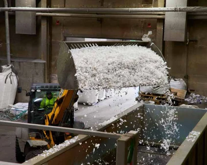 Skopa med strimlad plast, redo för återvinning eller vidare bearbetning. Materialåtervinning av plastavfall för tillverkning av nya produkter.